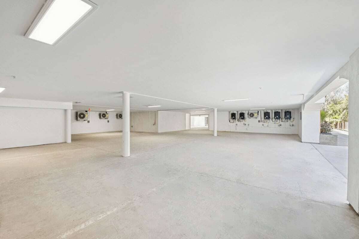 A spacious, modern interior with high ceilings and a concrete floor.