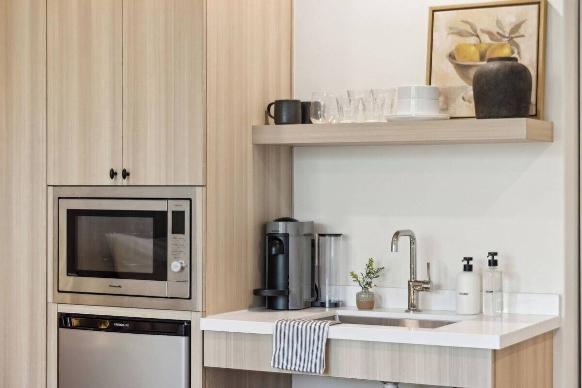 Una cocina moderna con microondas integrado, cafetera y lavavajillas.