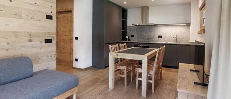 A modern kitchen with a built-in stove, dark cabinetry, and a grey backsplash.