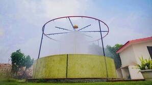 A circular water feature with a central fountain, surrounded by a metal structure. -  Royal green  Spacious farmhouse with 8 bedrooms and AC, WiFi in charming Sohna (Sohna)