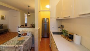 A compact kitchen with white cabinets, a stainless steel refrigerator, and a small countertop. - Lovely 2 Bdr Apartment in Heart of Kotor (Dobrota)