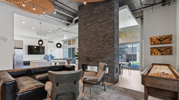 Ein moderner Lounge-Bereich mit Ledersofas, einem Billardtisch und einer Steinsäule.