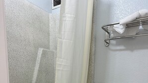 A bathroom with a shower, toilet, and towel rack.