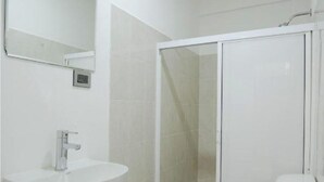 A bathroom with a white sink, toilet, and shower. - Hotel El Rincón (San Francisco del Rincón)