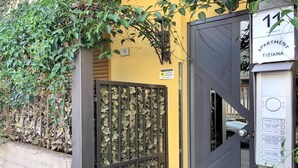 A gated entrance to an apartment building with a sign indicating 'Apartment Tiziana' and a number '11'.
