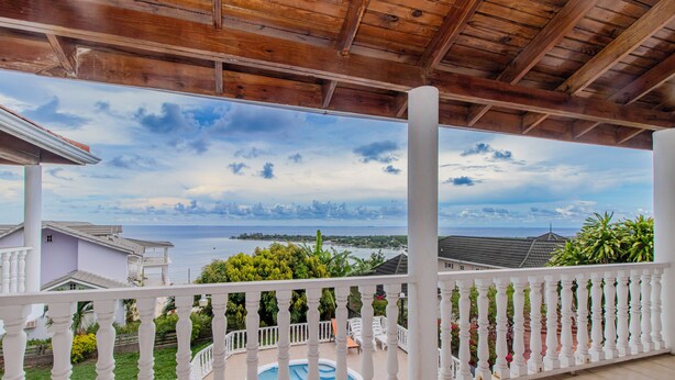 A covered balcony with a view of the sea and a swimming pool. - Large Seaview 3 Bedroom Villa with Private Pool, Terrace & Parking (Discovery Bay)