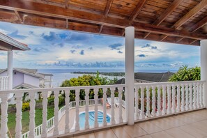 A covered balcony with a view of the sea and a swimming pool. - Large Seaview 3 Bedroom Villa with Private Pool, Terrace & Parking (Discovery Bay)