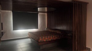 Un dormitorio con cama, ventana y pared con listones verticales.