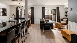 Una cocina moderna con barra, una mesa de comedor y un sofá en la sala de estar.