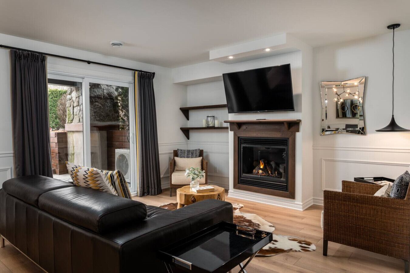 A modern living room with a fireplace, a flat-screen TV, and a comfortable seating area.