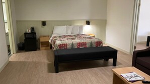 Une chambre à coucher comprenant un lit, une table de chevet, une petite table et un banc.