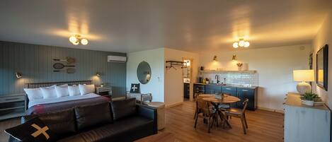 Una sala moderna con sofá, mesa de comedor y zona de cocina.