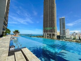 室外游泳池，池畔遮阳伞，日光浴躺椅