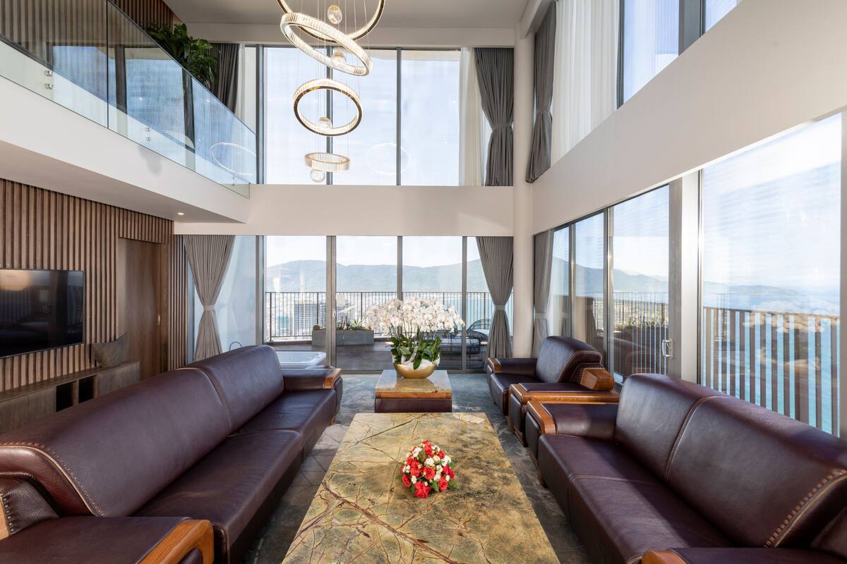 Un interior moderno con sofás de cuero, una mesa de centro y ventanas amplias que ofrecen vista a la ciudad.