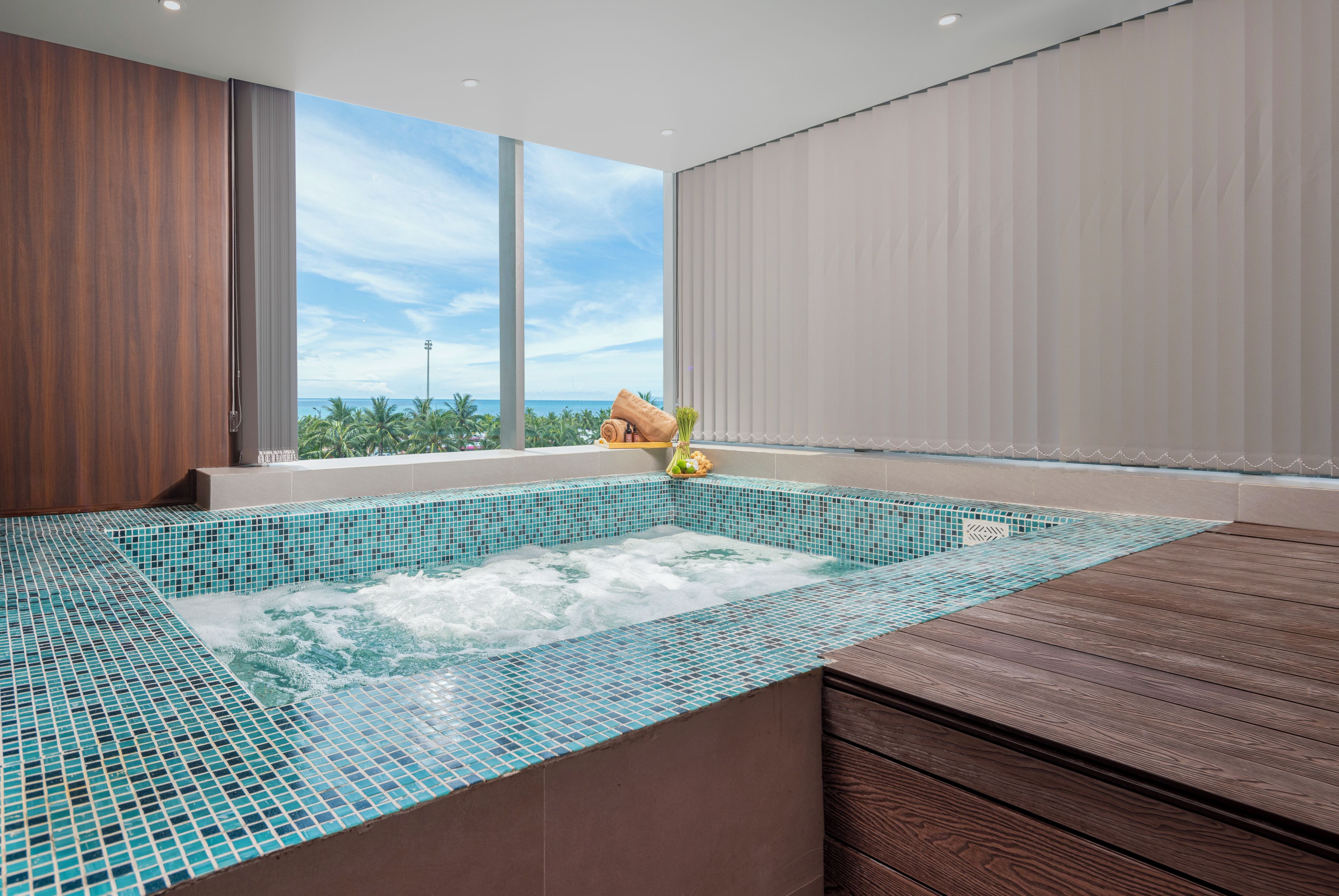 A modern bathroom with a large window, a jacuzzi, and a wooden vanity.