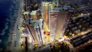 A high-rise building with multiple floors, surrounded by a well-lit urban area with roads and greenery. - Wyndham Soleil Danang - Free Schedule Airport Shuttle (Da Nang)