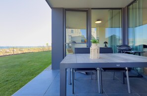 Outdoor dining - Lykke vacation apartment - pure sea view. Sauna. Family-friendly. (Fehmarn)