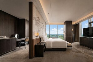 Una habitación de hotel moderna con una cama grande, un escritorio, una silla y un televisor.