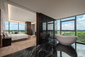 A modern bedroom with a large bed, a bathroom with a freestanding bathtub, and a view of the landscape through large windows. - Howard Johnson By Wyndham Guotou Plaza Zigong (Zigong)