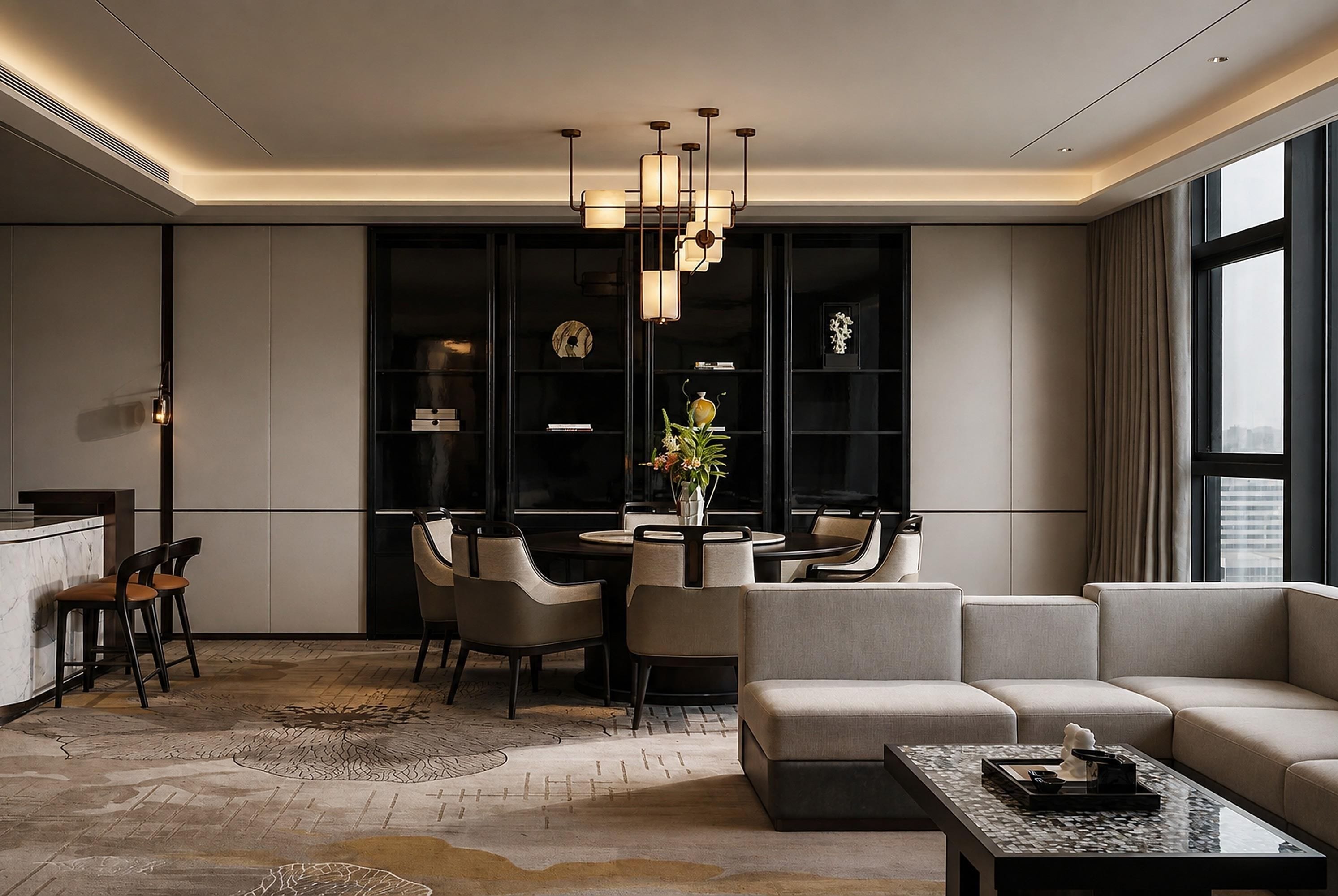 Un hall d’hôtel moderne comprenant un espace repas, des coins salon et une grande fenêtre offrant une vue panoramique.