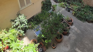 Een binnentuin met plantenpotten en een metalen hekwerk.