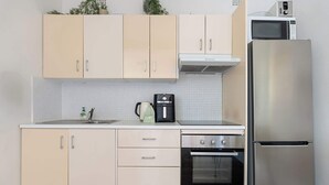 A kitchen with light-colored cabinets, a stainless steel refrigerator, a microwave, a coffee maker, and an oven. - Spacious and Idyllic Unit in Little Manly (Manly)