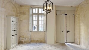 Une pièce dotée d’une grande fenêtre en arc de cercle, d’une porte avec une poignée et d’un meuble blanc comportant plusieurs compartiments.