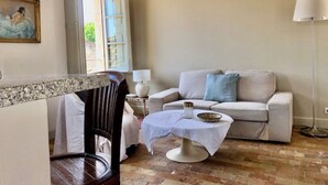 Un salon avec un canapé, une table basse et un lampadaire.