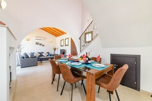 Ein Essbereich mit einem Holztisch, braunen Stühlen und einer Treppe, die zu einer oberen Ebene führt.