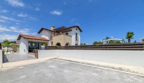 Eine Villa mit Steinaußenwand, Ziegeldach und Holzzaun.