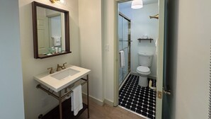 A bathroom with a white sink, mirror, and toilet. - King Room With Balcony - NKB (Gatlinburg)