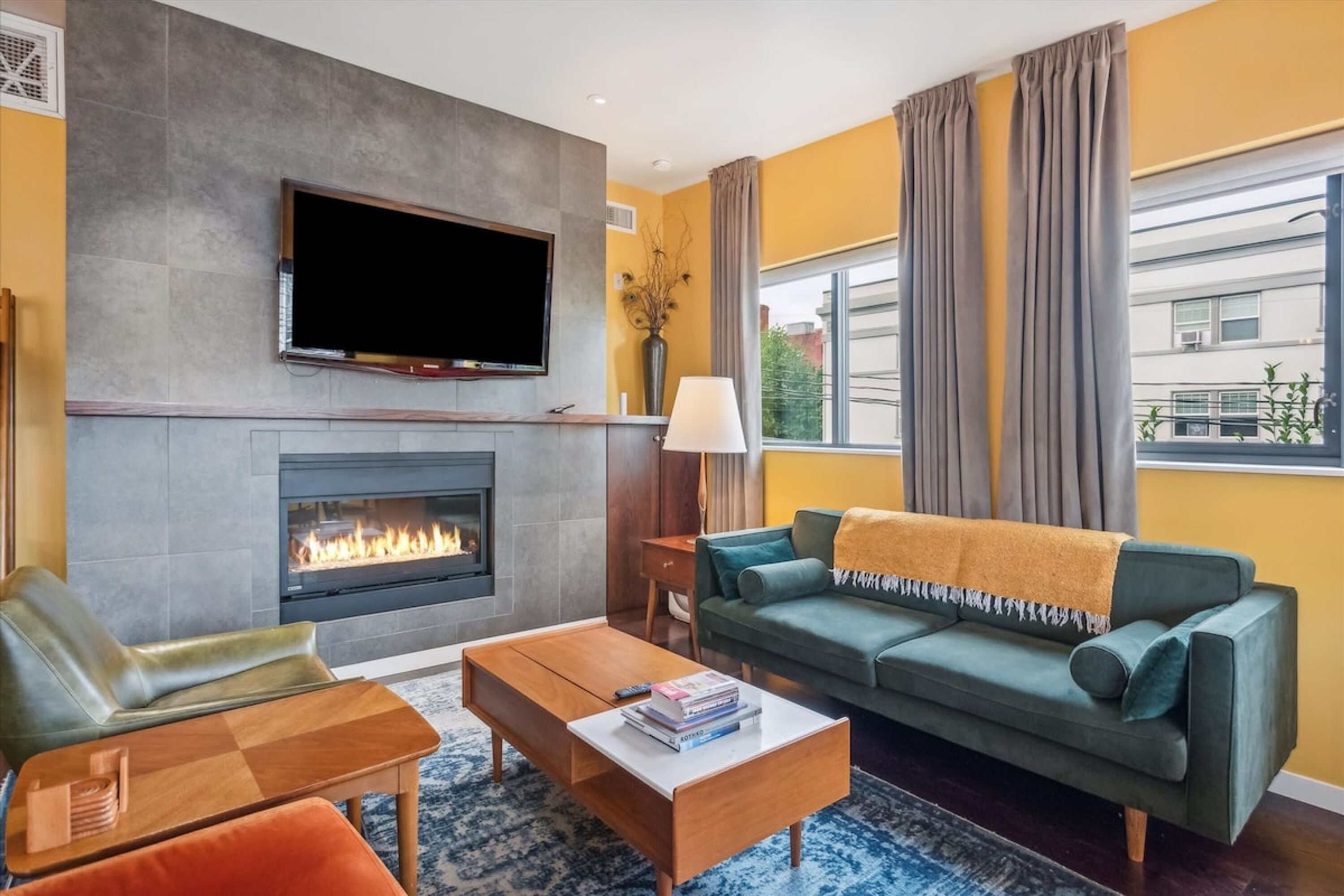 A modern living room with a fireplace, a flat-screen TV, a sofa, and a coffee table.