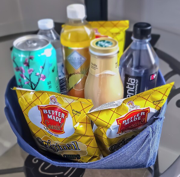 A tray with various beverages and snacks, including a can, bottles, and two bags of chips. - Charming 2-bedroom apartment near Downtown Dearborn (Dearborn)