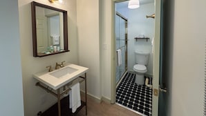 A bathroom with a white sink, mirror, and toilet. - Standard King Room - NKS (Gatlinburg)
