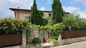 Una casa in pietra con facciata in pietra, una piccola finestra e un portone.