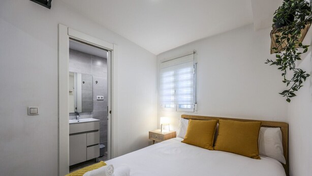 Una habitación de hotel con cama, baño y ventana.