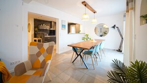 Une cuisine moderne dotée d’un plan de travail en bois, d’un four encastré et d’un coin repas avec une table en bois et des chaises bleues.