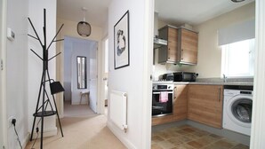 A compact kitchen with a washing machine, a microwave, and a stove.
