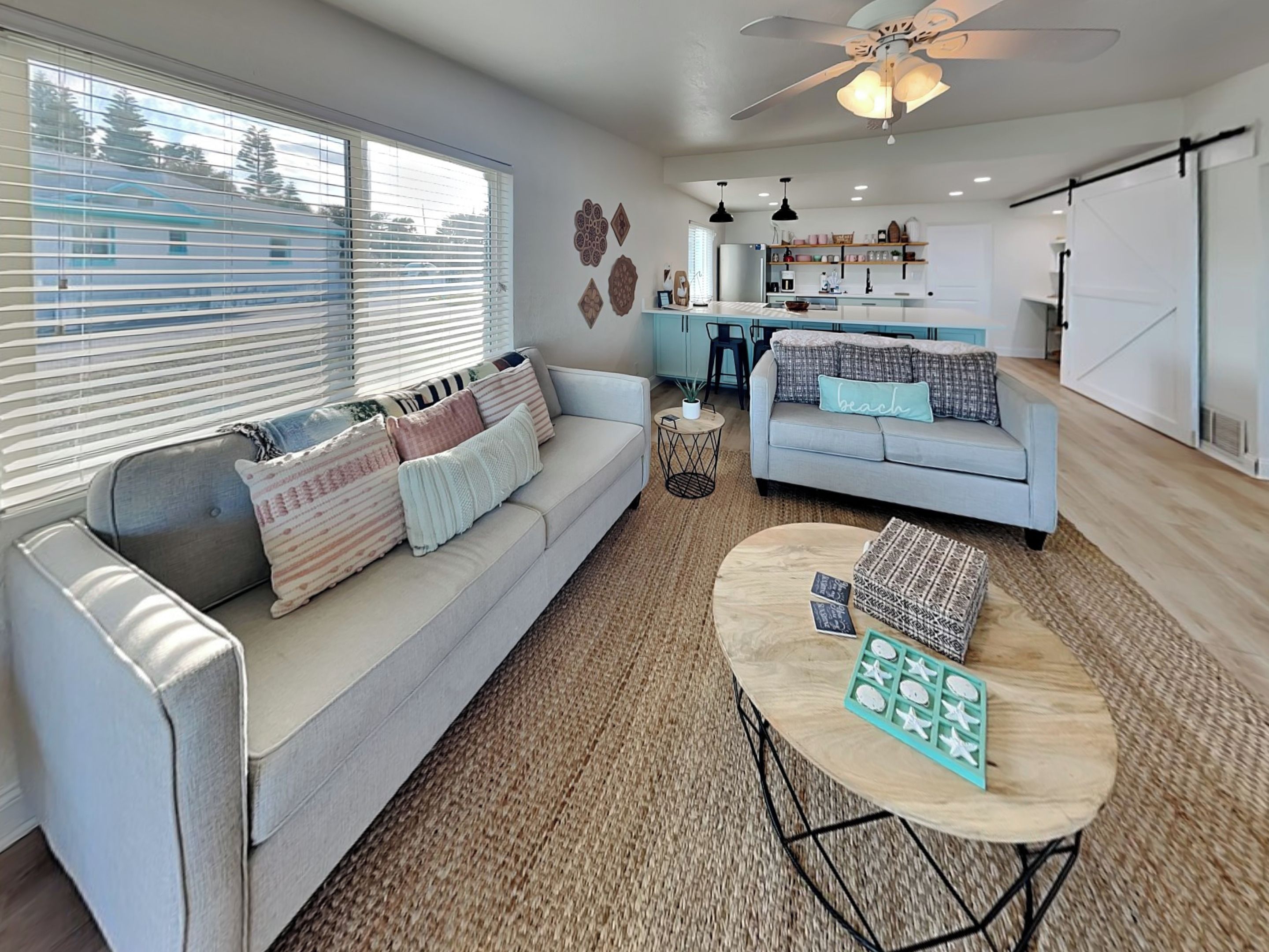 A modern living room with a sofa, a coffee table, and a kitchen in the background.