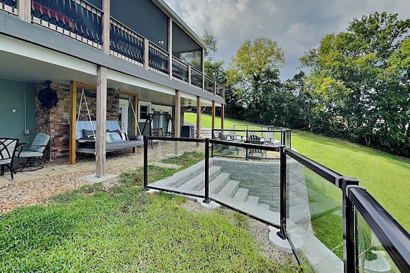A two-story building with a balcony, outdoor seating, and a grassy yard. - Sunset Cove by Jackson Mountain Rentals (Dandridge)