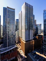 Un complejo de edificios urbanos de gran altura, con varios pisos, amplias ventanas y una mezcla de estilos arquitectónicos modernos y tradicionales.