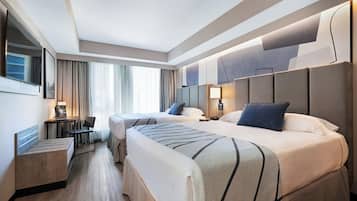 Een moderne hotelkamer met twee bedden, een bureau, een stoel en een televisie.