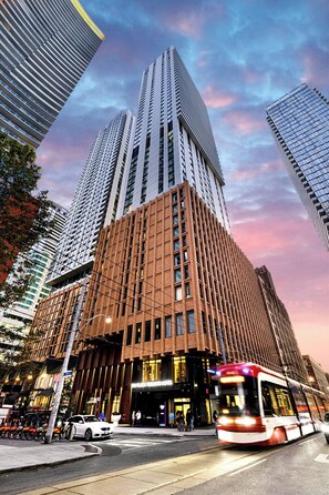 A modern hotel with a prominent corner entrance, large windows, and a visible street view. - Hotel Riu Plaza Toronto (Toronto)