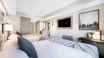 Een hotelkamer met twee bedden, een bureau, een televisie en een stadsgezichtschilderij.