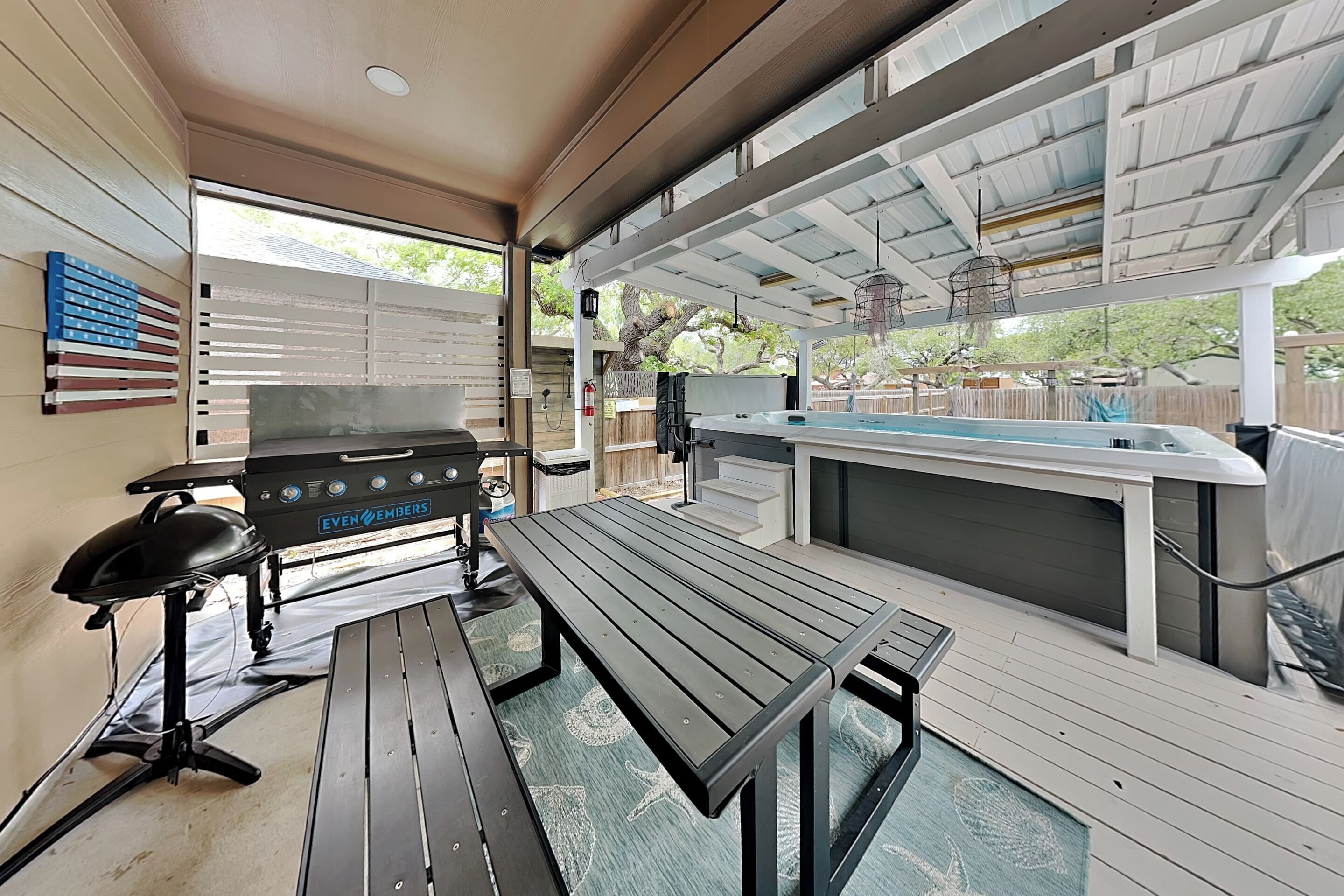 Eine Terrasse im Freien mit Grill, Tisch und Barbereich.