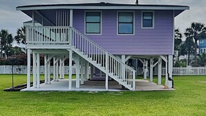 Une maison à deux étages dotée d’un balcon et d’un escalier menant au deuxième étage.