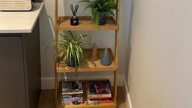 Ein Holzregal mit Dekoration und Büchern.