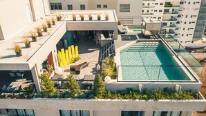 A rooftop pool area with a glass enclosure, outdoor seating, and potted plants. - RL1 707 in Santo Domingo de Guzm n (Santo Domingo)