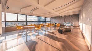 A spacious, modern lounge with large windows, wooden flooring, and yellow chairs. - RL1 707 in Santo Domingo de Guzm n (Santo Domingo)