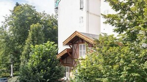 A two-story building with a white facade and a traditional wooden balcony. - Chez Juliette - 4 rue de Serbie - Vichy (Vichy)